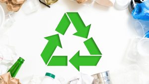 Symbole de recyclage vert sur fond de matières recyclables — tri 5 flux professionnels IDS Environnement