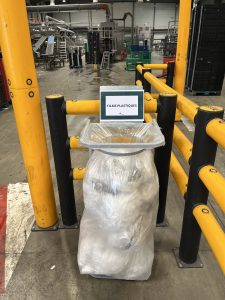 Porte-sac "Films Plastiques" installé dans une zone sécurisée délimitée par des barrières jaunes et noires chez ETERNITY SYSTEMS Cestas — organisation des flux de déchets par IDS Environnement Gironde.