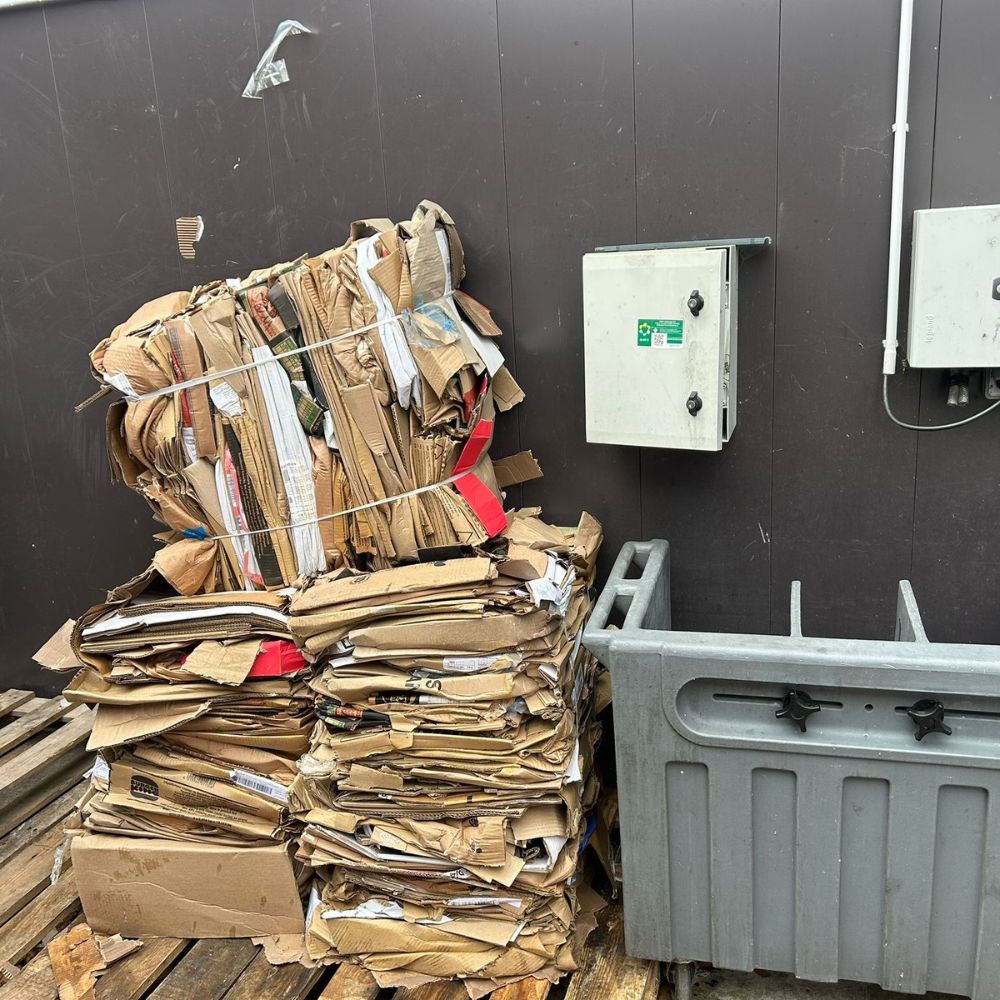Même zone de stockage après installation de la presse à balles Clean Kompact : trois balles de carton rangées
